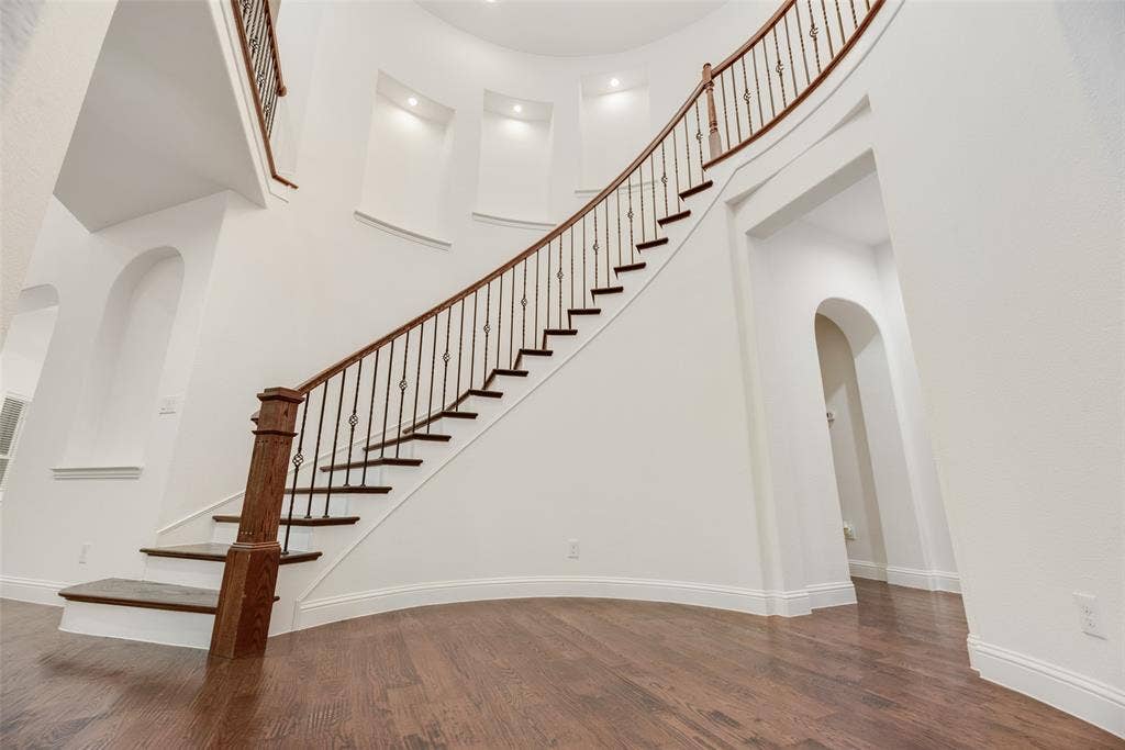 2408 Brisbane Lane, Plano, TX 75075 Curved staircase with wood-finish treads and wrought iron balusters