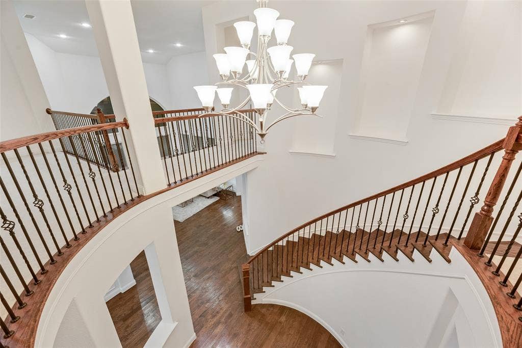 2408 Brisbane Lane, Plano, TX 75075 Grand curved staircase with rich wood treads and wrought iron balusters