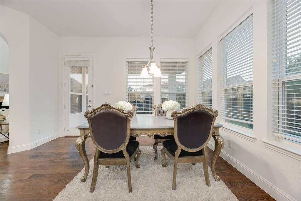 2408 Brisbane Lane, Plano, TX 75075 Hardwood flooring, multiple windows with blinds, a built-in archway, and a glass-paneled door