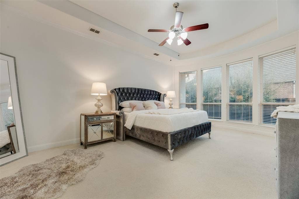 2408 Brisbane Lane, Plano, TX 75075 Recessed lighting, ceiling fan with light fixture, tray ceiling, multiple windows with blinds, and light-colored carpeting