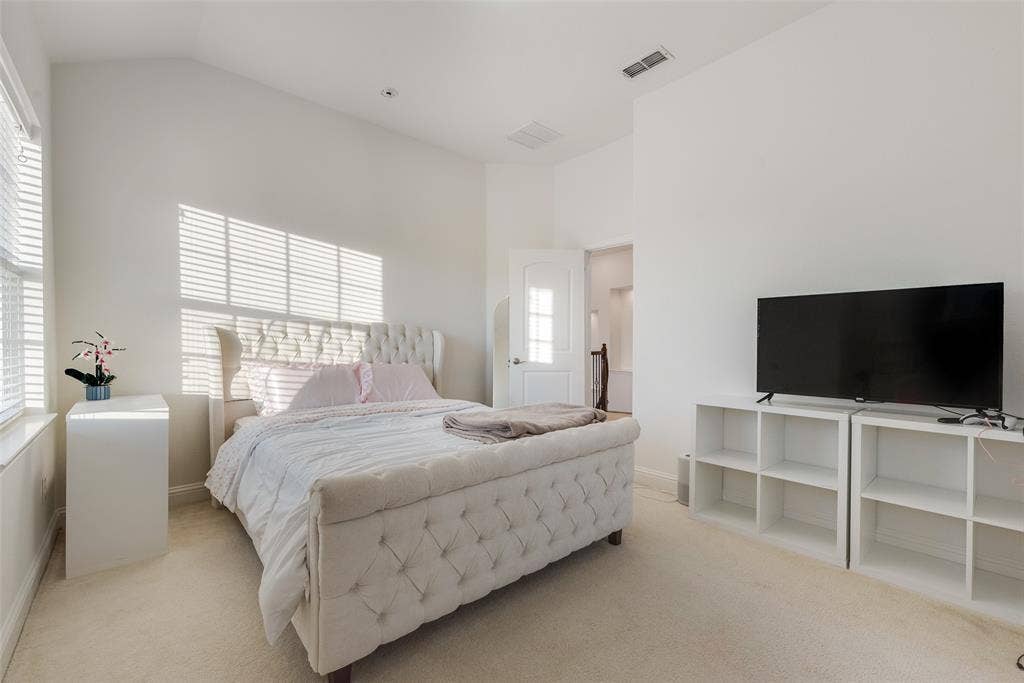 2408 Brisbane Lane, Plano, TX 75075 Vaulted ceiling, neutral wall paint, carpet flooring, window with blinds, white paneled door