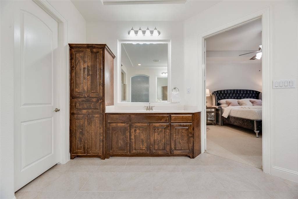 2408 Brisbane Lane, Plano, TX 75075 Bathroom vanity with a single sink, light-colored countertop, and a large mirror