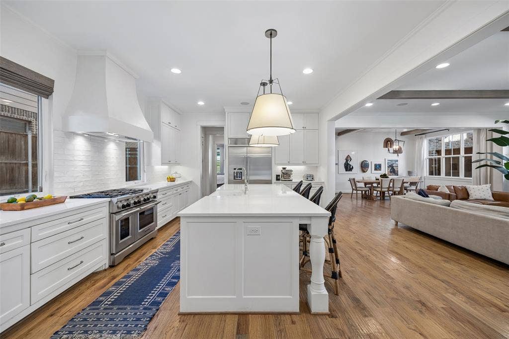 7318 Casa Loma Avenue, Dallas, TX 75214 Open white on white kitchen with beautiful quartz countertops, Viking gas range and built in stainless steel refrigerator.