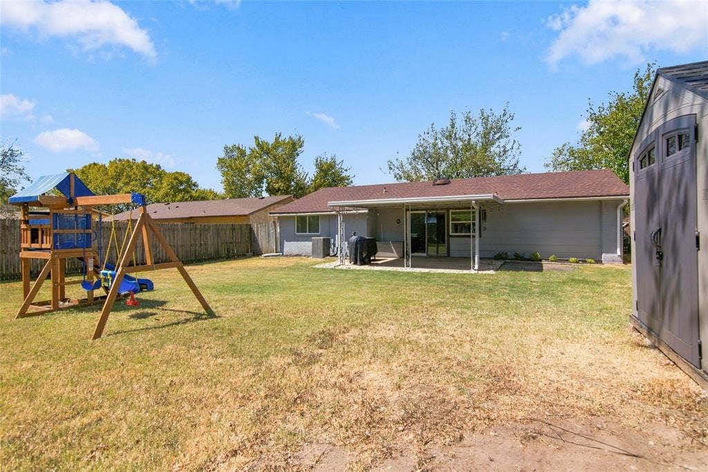 4720 Kyle Drive, Balch Springs, TX 75180 Expansive backyard featuring a covered patio, sliding glass door, and a storage shed