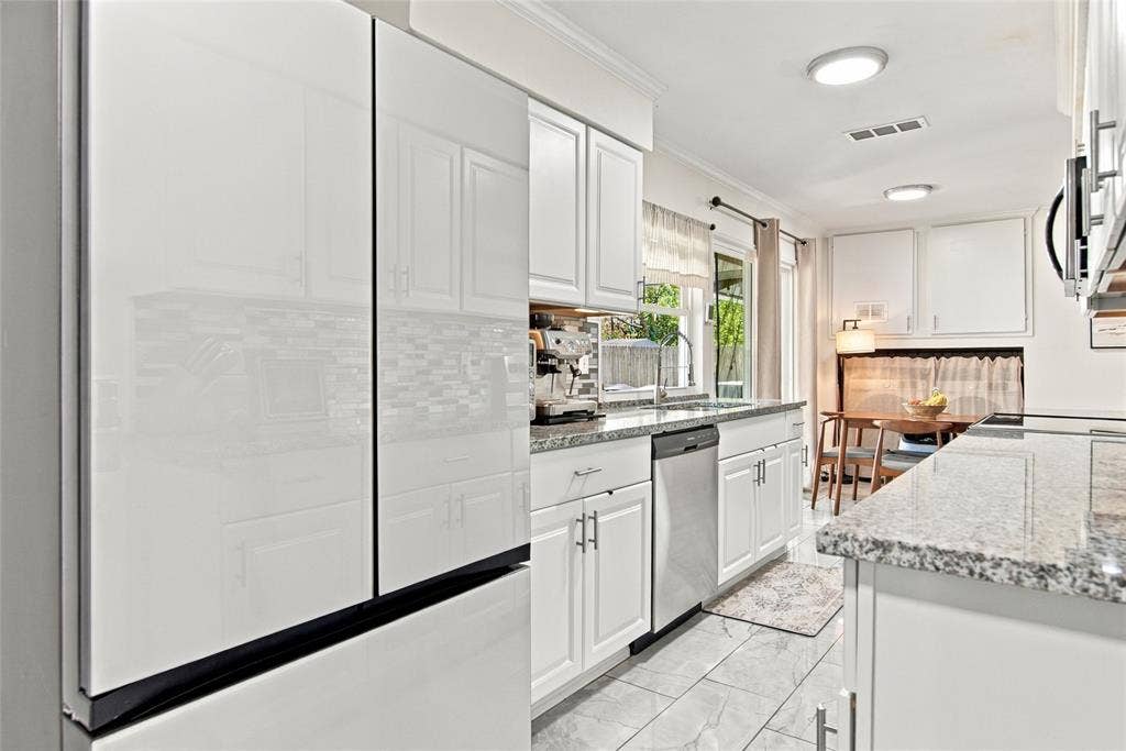 4720 Kyle Drive, Balch Springs, TX 75180 White cabinetry with brushed nickel hardware, light-toned granite-style countertops, mosaic tile backsplash, and recessed lighting