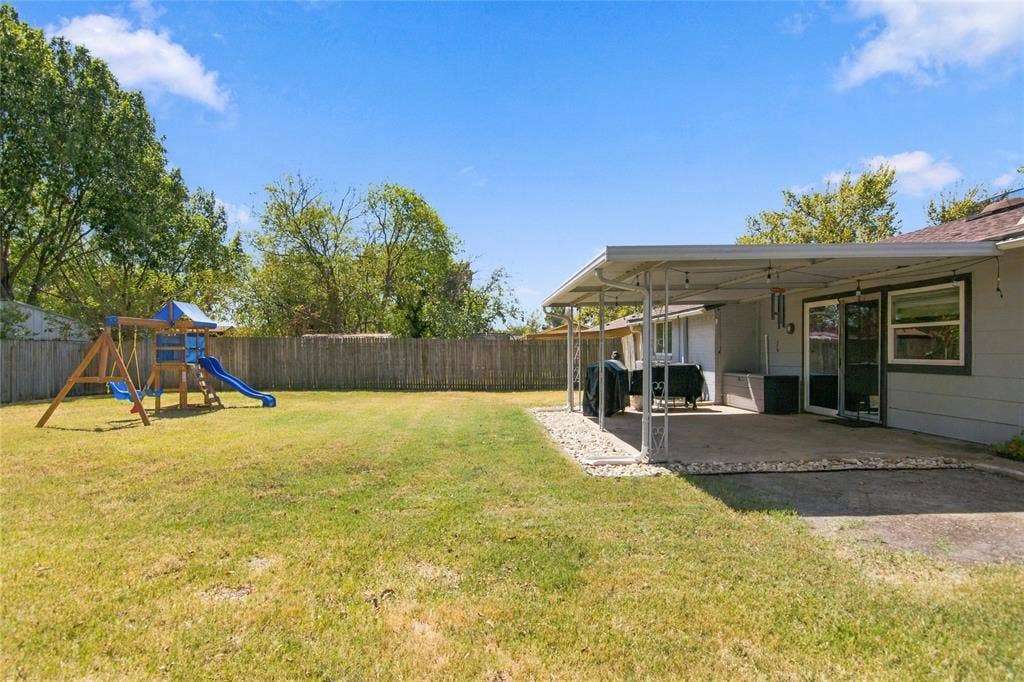 4720 Kyle Drive, Balch Springs, TX 75180 Expansive fenced yard featuring a covered patio with concrete flooring, a sliding glass door, and exterior windows