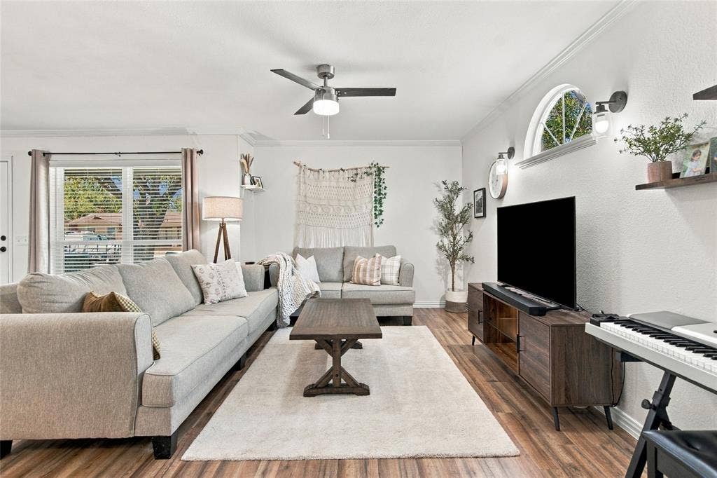4720 Kyle Drive, Balch Springs, TX 75180 Wood-finish flooring, ceiling fan with integrated lighting, arched window, and recessed wall sconces