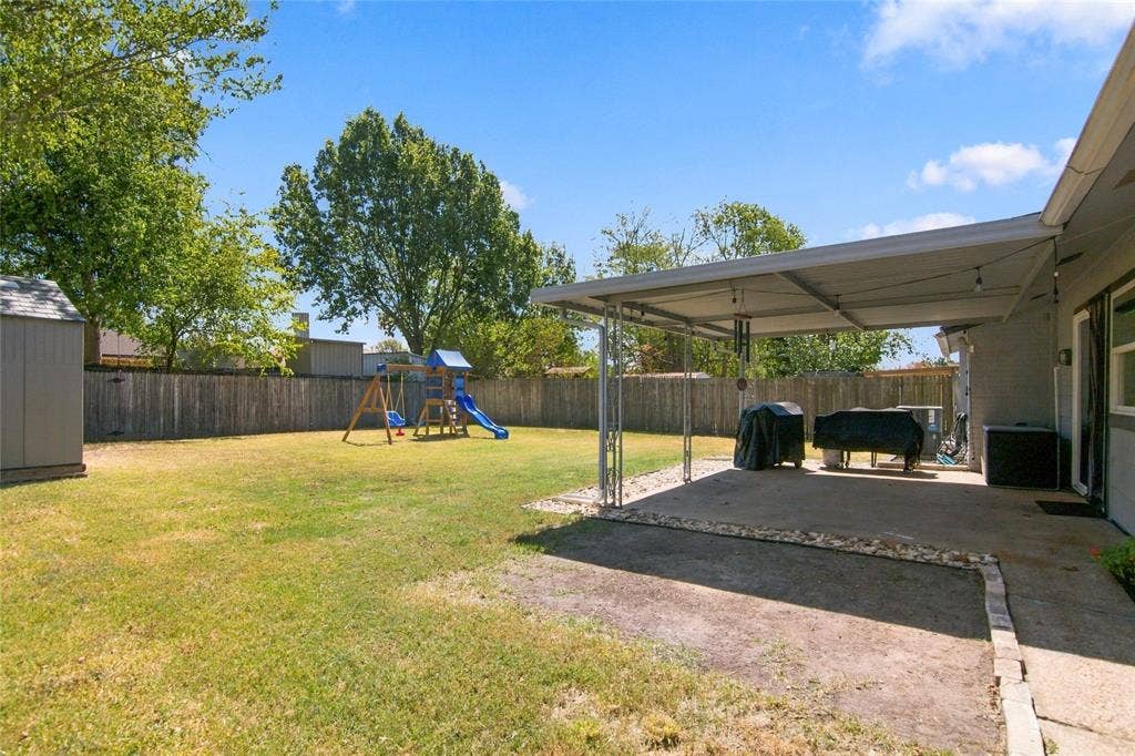 4720 Kyle Drive, Balch Springs, TX 75180 Expansive backyard featuring a covered patio, concrete paving, a wood privacy fence, and a storage shed