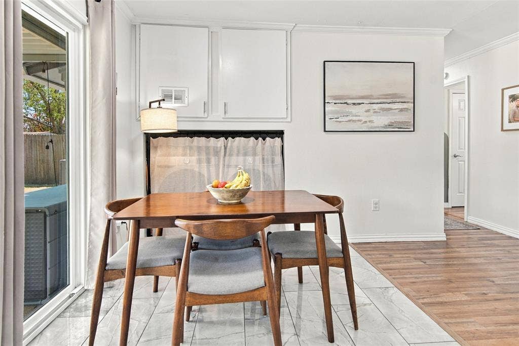 4720 Kyle Drive, Balch Springs, TX 75180 Sliding glass door, white wall cabinetry, crown molding, wood-finish flooring, and light-toned tile flooring