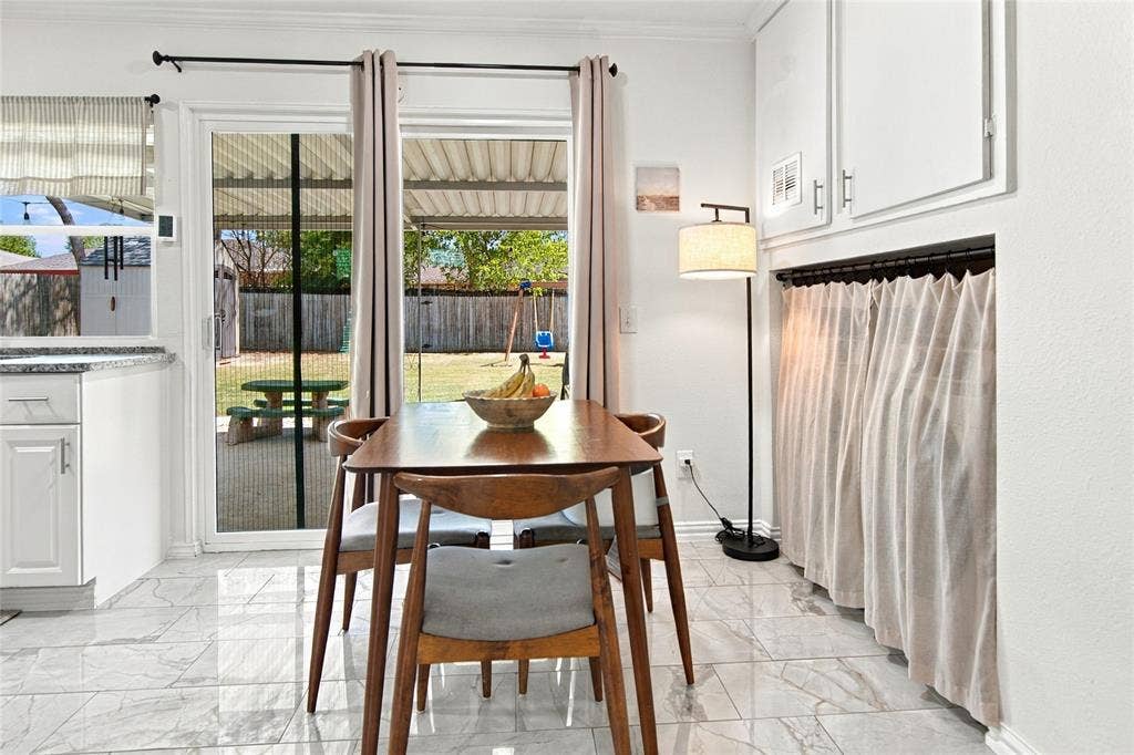 4720 Kyle Drive, Balch Springs, TX 75180 White shaker cabinetry, light-toned tile flooring, and a sliding glass door with screen leading to the exterior