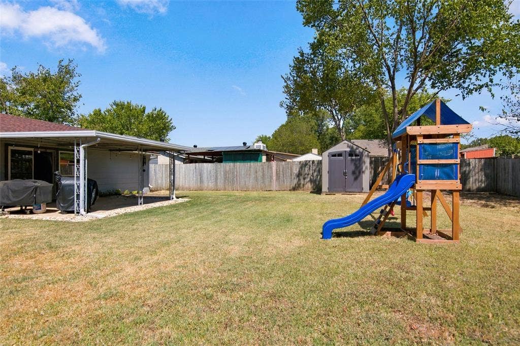 4720 Kyle Drive, Balch Springs, TX 75180 Expansive backyard featuring a covered patio, a manicured lawn, a privacy fence, and a storage shed