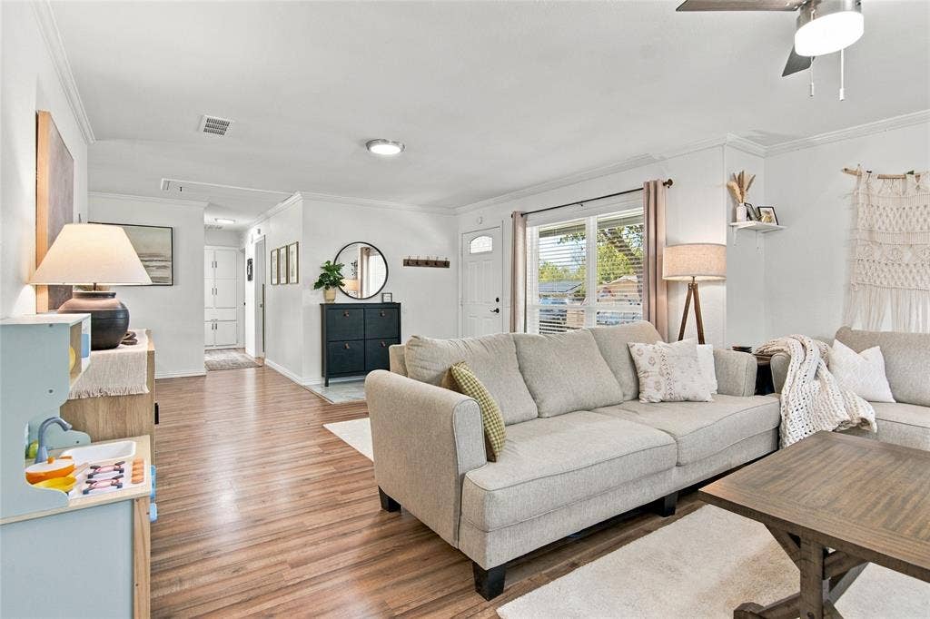 4720 Kyle Drive, Balch Springs, TX 75180 Wood-finish flooring, white walls, crown molding, and a ceiling fan with integrated lighting