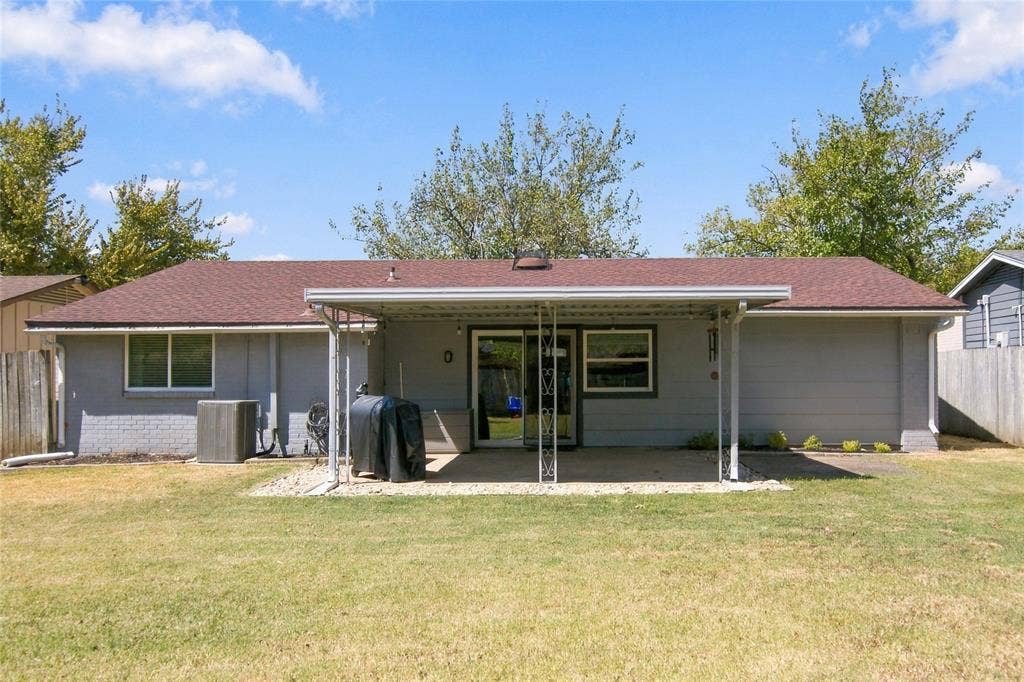 4720 Kyle Drive, Balch Springs, TX 75180 Expansive backyard featuring a covered patio, sliding glass door access, and a durable shingle roof
