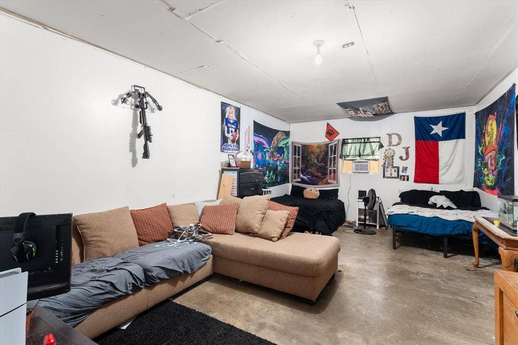 402 E Cook Street, Eustace, TX 75124 Interior room featuring exposed concrete flooring, white walls, and a single ceiling-mounted light fixture