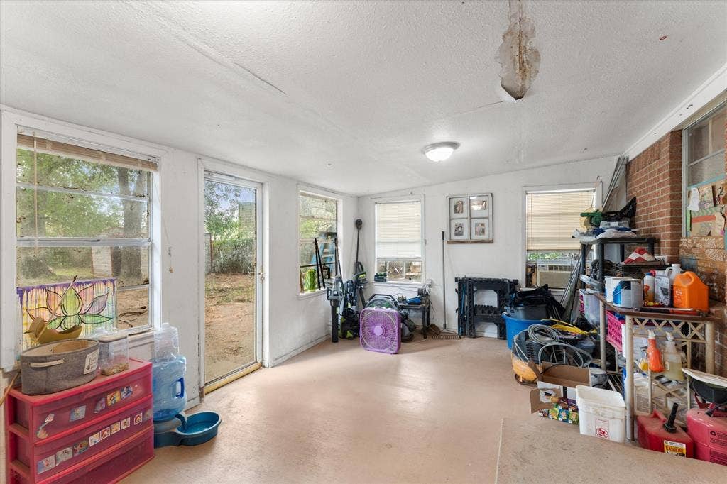 402 E Cook Street, Eustace, TX 75124 Enclosed porch featuring multiple windows, exposed brick wall, and direct exterior access