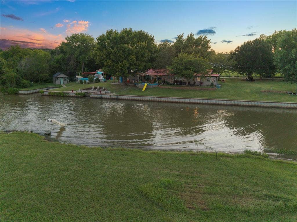 308 Causeway Cove, Seven Points, TX 75143 Waterfront property featuring a detached shed, dock with ladder, and expansive green lawn