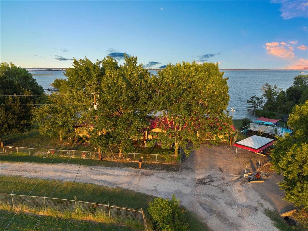 308 Causeway Cove, Seven Points, TX 75143 Waterfront property with mature trees, fenced perimeter, and a detached covered structure