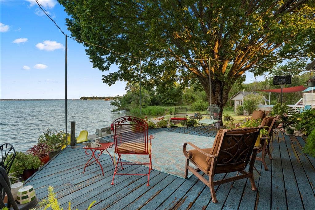 308 Causeway Cove, Seven Points, TX 75143 Waterfront wood-plank deck with a prominent mature tree, featuring a large body of water, and an expansive natural landscape