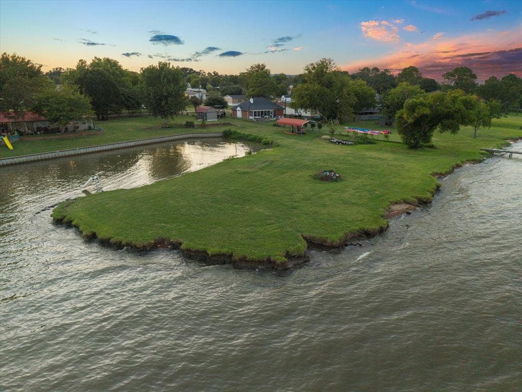 308 Causeway Cove, Seven Points, TX 75143 Waterfront property featuring a private canal, lush green lawn, and mature trees