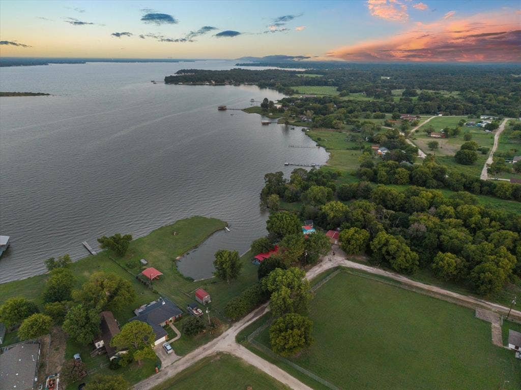 308 Causeway Cove, Seven Points, TX 75143 Expansive lakefront property featuring a private dock, lush green landscaping, and mature trees