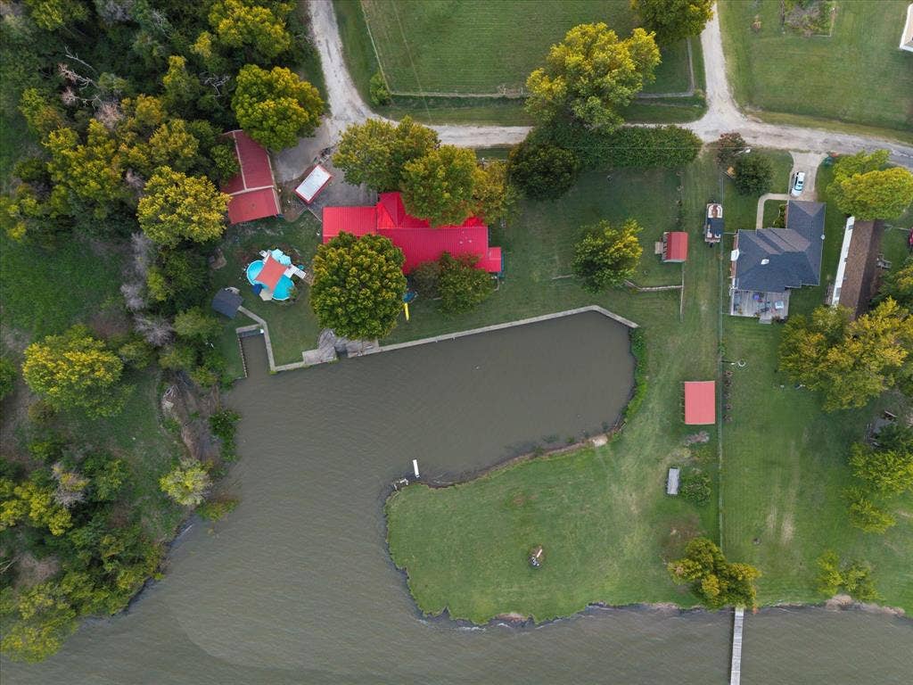 308 Causeway Cove, Seven Points, TX 75143 Waterfront property with a private pond, main residence featuring a red roof, and an additional structure with a red roof