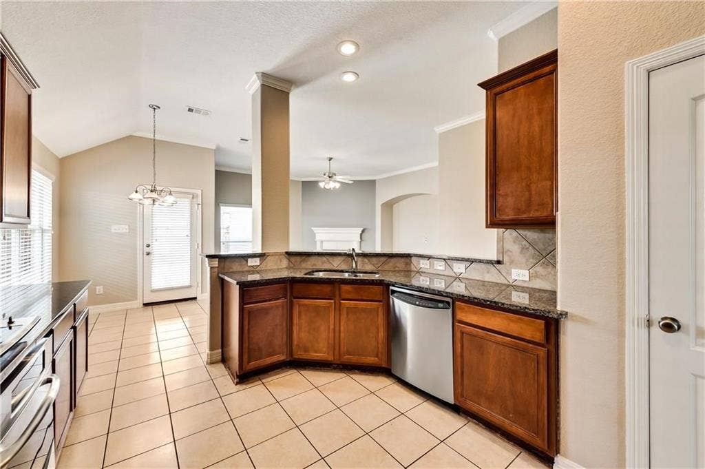 4637 Dwarf Nettle Drive, Fort Worth, TX 76244 Kitchen featuring wood cabinetry, dark countertops, a tile backsplash, and stainless steel appliances