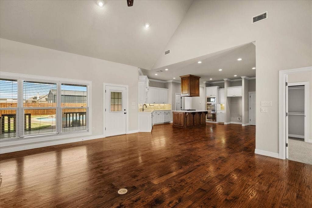 3674 County Road 2142, Caddo Mills, TX 75135 Vaulted ceiling, recessed lighting, wood-finish flooring, white cabinetry, and a kitchen island with a wood base