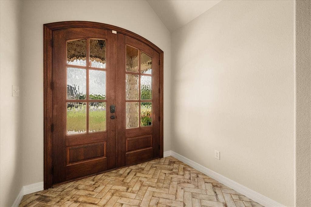 3674 County Road 2142, Caddo Mills, TX 75135 Arched double entry doors with textured glass, wood-finish flooring in a herringbone pattern, and neutral wall tones