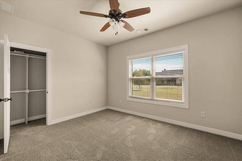 3674 County Road 2142, Caddo Mills, TX 75135 Neutral-toned walls with carpeted flooring, featuring a ceiling fan with integrated lighting