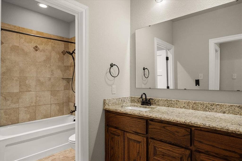 3674 County Road 2142, Caddo Mills, TX 75135 Vanity with a granite countertop and wood-finish cabinetry