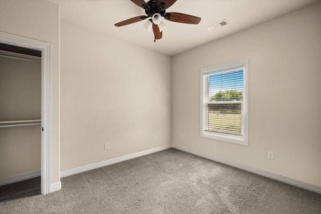 3674 County Road 2142, Caddo Mills, TX 75135 Recessed closet with a built-in shelf and hanging rod, carpeted flooring, and a ceiling fan with light fixture