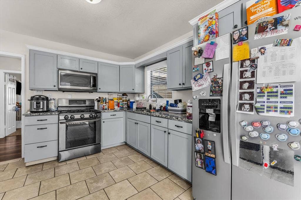 3605 Rolando Avenue, Waco, TX 76711 Kitchen featuring tile flooring, light gray cabinetry, stainless steel appliances, and dark countertops