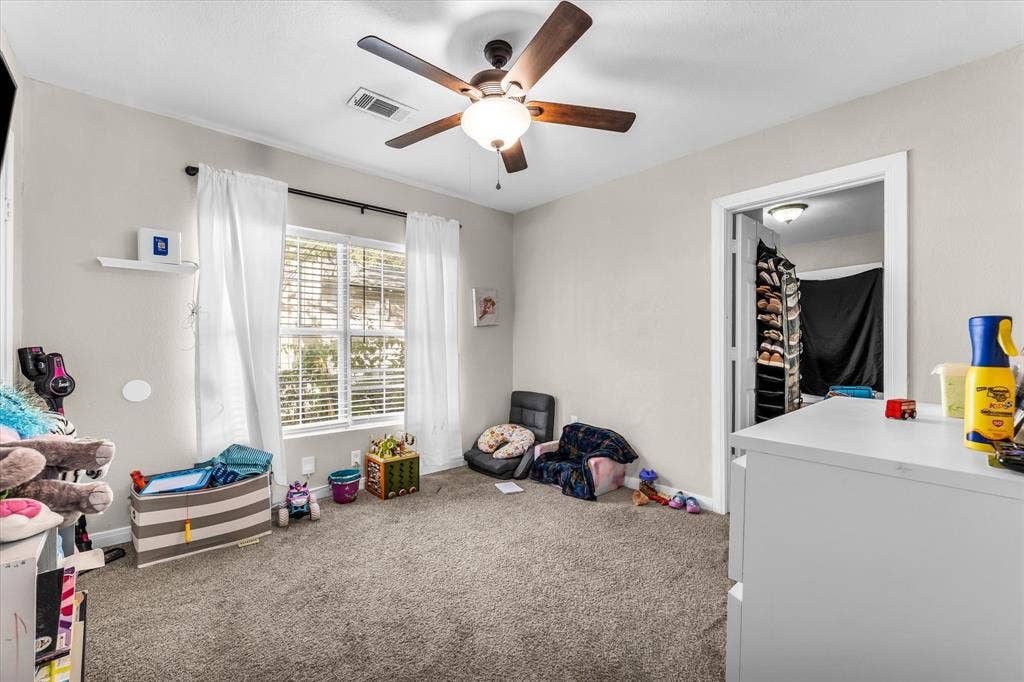 3605 Rolando Avenue, Waco, TX 76711 Carpeted room with a ceiling fan, a window with blinds, and an open doorway to a closet