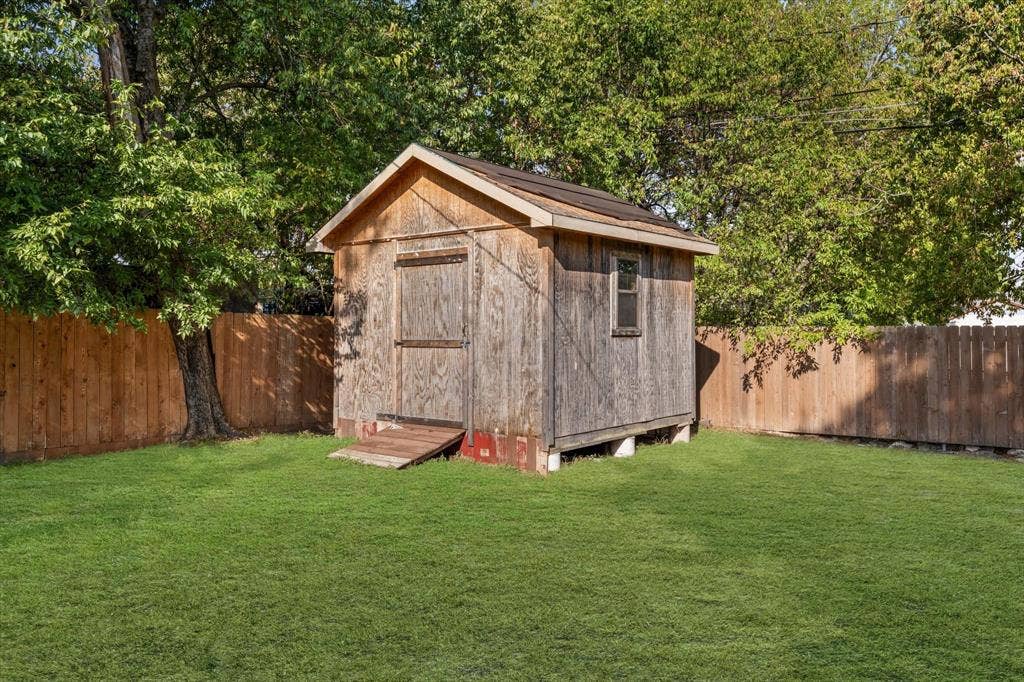 3605 Rolando Avenue, Waco, TX 76711 Expansive green lawn featuring a wooden storage shed with a window and solid wood fencing