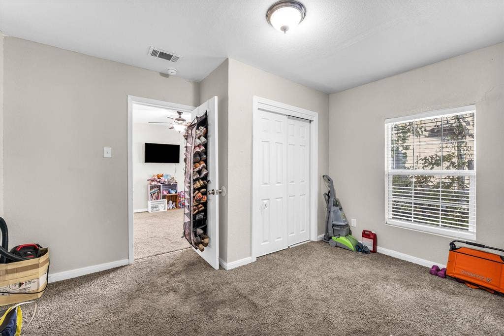 3605 Rolando Avenue, Waco, TX 76711 Carpeted room with a single window, white window blinds, and a bi-fold closet door