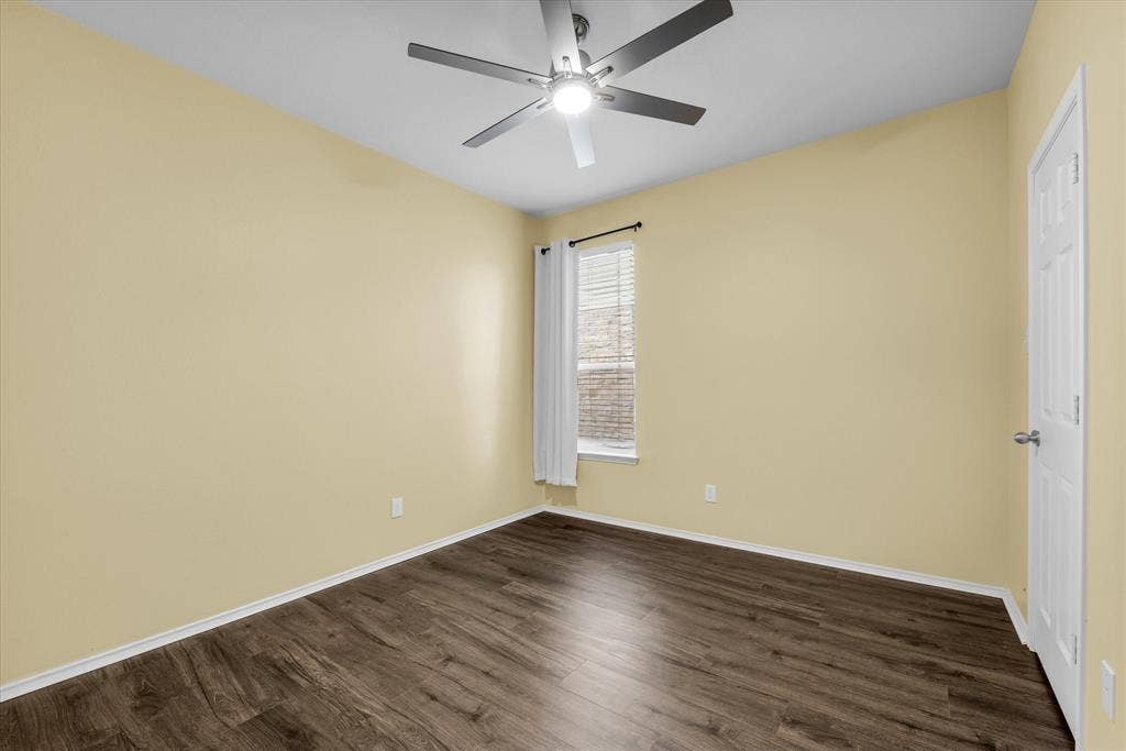 6621 Burling Street, Waco, TX 76712 Wood-finish flooring, ceiling fan with integrated lighting, white trim, and a window with blinds