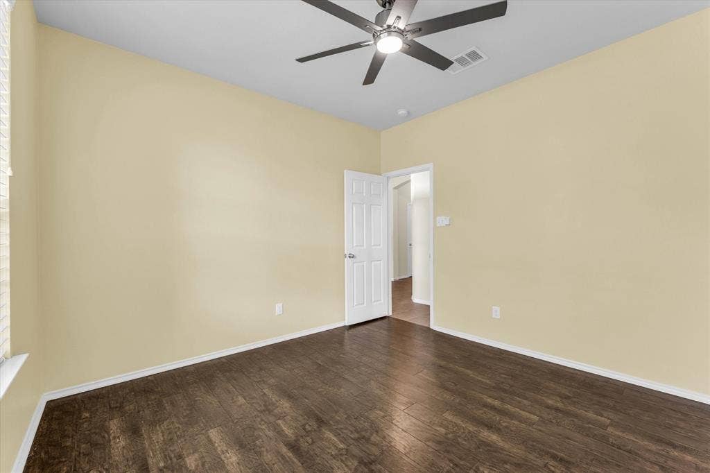 6621 Burling Street, Waco, TX 76712 Wood-finish flooring, ceiling fan with integrated lighting, and a white paneled door