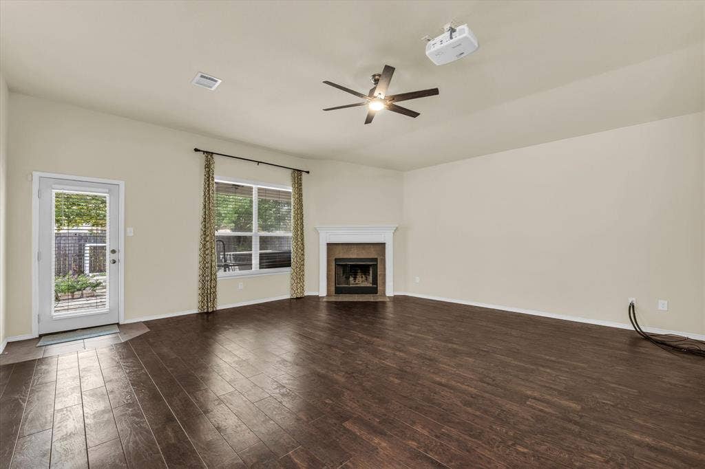 6621 Burling Street, Waco, TX 76712 Wood-finish flooring, fireplace with a white mantel, ceiling fan, and a glass-paned exterior door