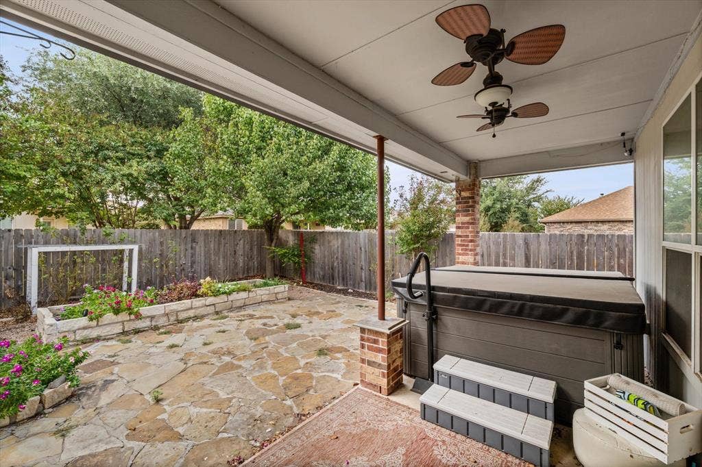6621 Burling Street, Waco, TX 76712 Covered patio with exposed brick support column, dual ceiling fans, and a built-in hot tub