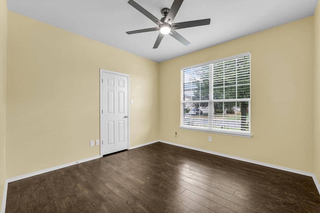 6621 Burling Street, Waco, TX 76712 Room featuring wood-finish flooring, a ceiling fan with integrated lighting, a multi-pane window with blinds, and a paneled interior door