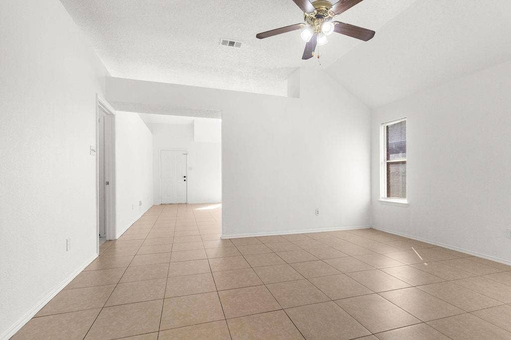 Vaulted ceiling, ceramic tile flooring, and integrated ceiling fan with multi-bulb light fixture