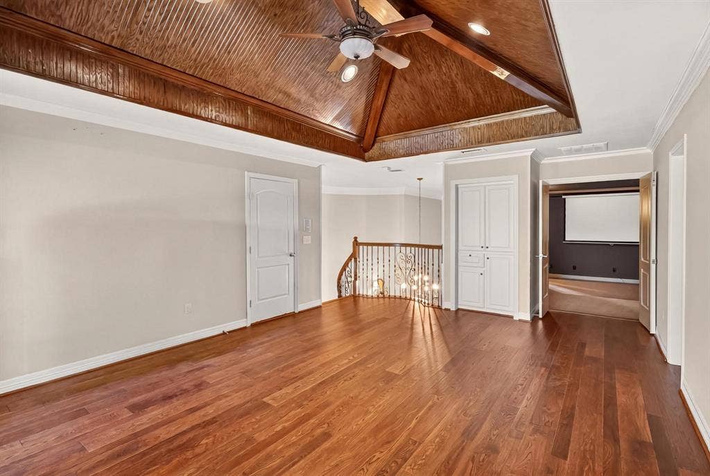 112 Winsley Circle, McKinney, TX 75071 Expansive game room with wood finished flooring, vaulted wood-paneled ceiling, ceiling fan, and white built-in cabinetry. Attached media room.