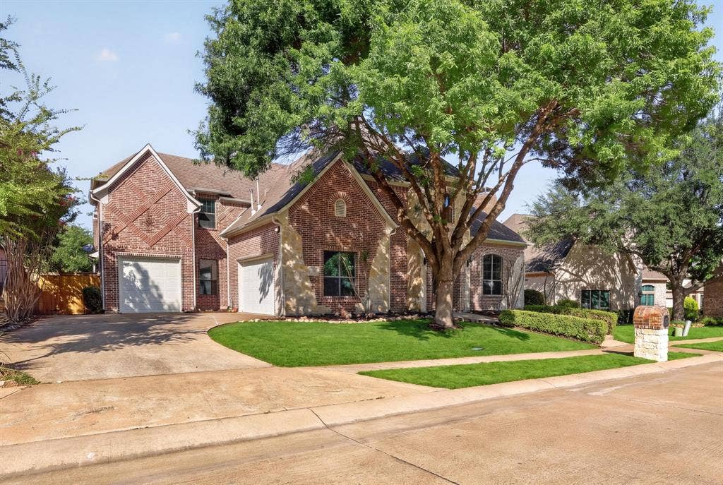 112 Winsley Circle, McKinney, TX 75071 Brick and stone veneer exterior with a three-car garage, mature trees, and a extra long drive-way