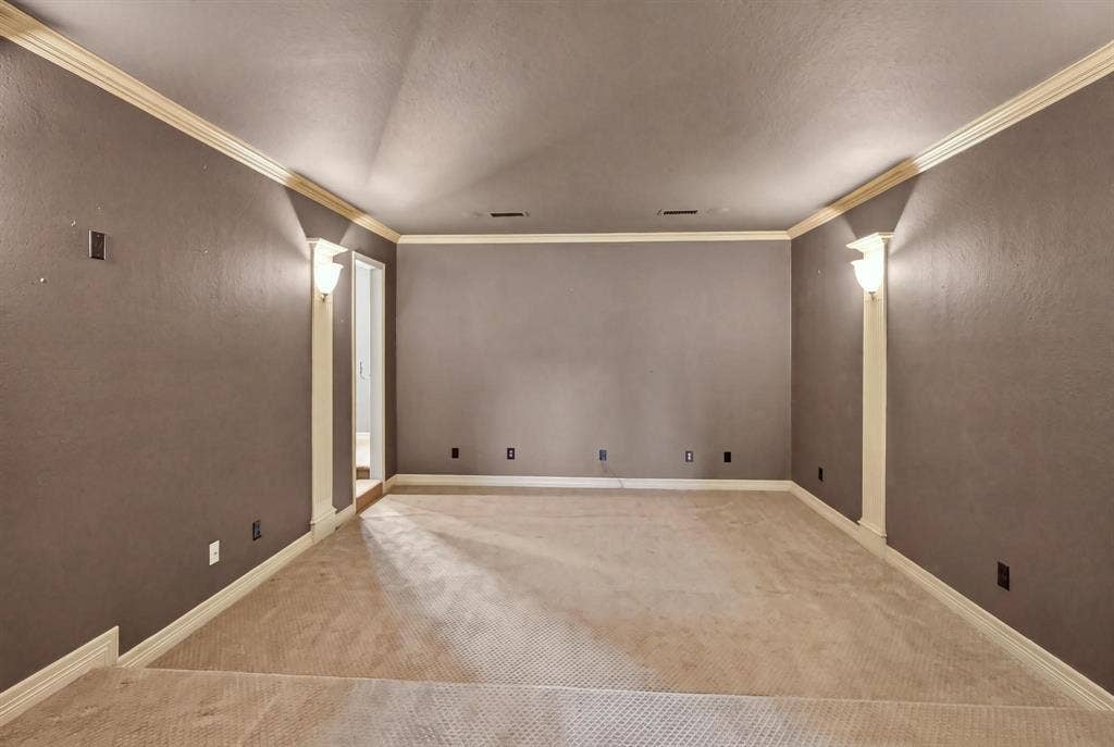 112 Winsley Circle, McKinney, TX 75071 Spacious media room featuring wall-to-wall carpeting, crown molding, and decorative wall sconces