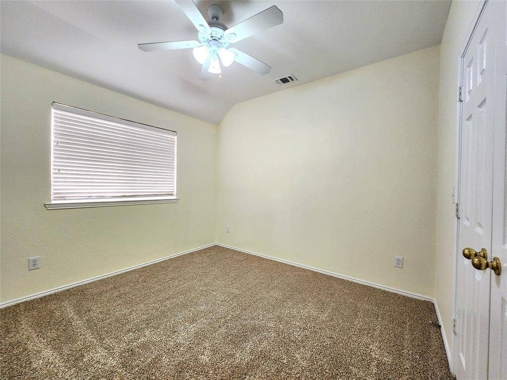 10307 Asheboro Street, Frisco, TX 75035 Textured carpeting, window with blinds, ceiling fan with light fixture, and a paneled door with brass hardware