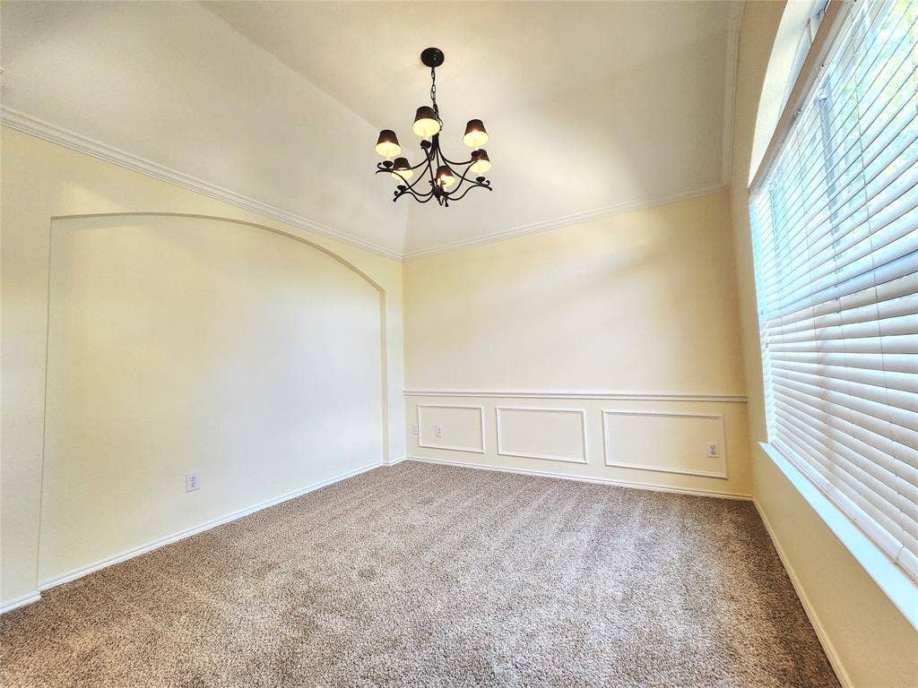 10307 Asheboro Street, Frisco, TX 75035 Vaulted ceiling with an ornate chandelier, arched entryway, wainscoting, and carpeted flooring