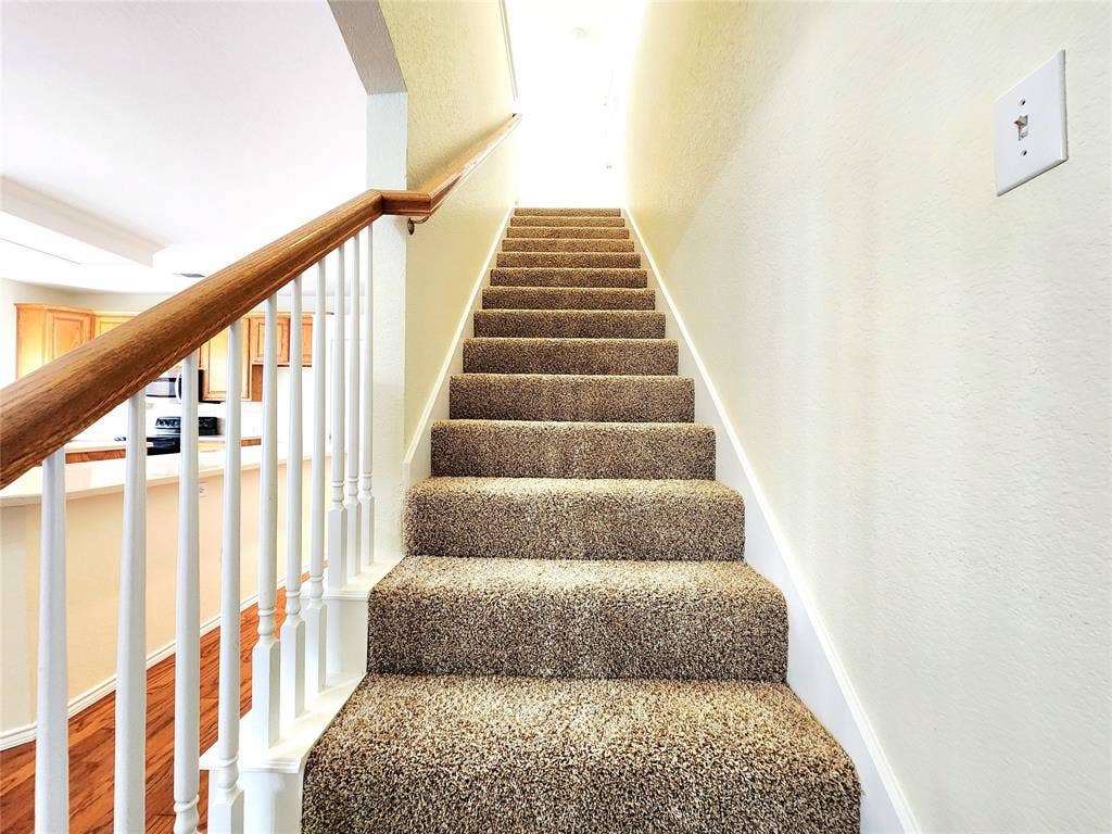 10307 Asheboro Street, Frisco, TX 75035 Carpeted staircase with a wood-finish handrail and white balusters