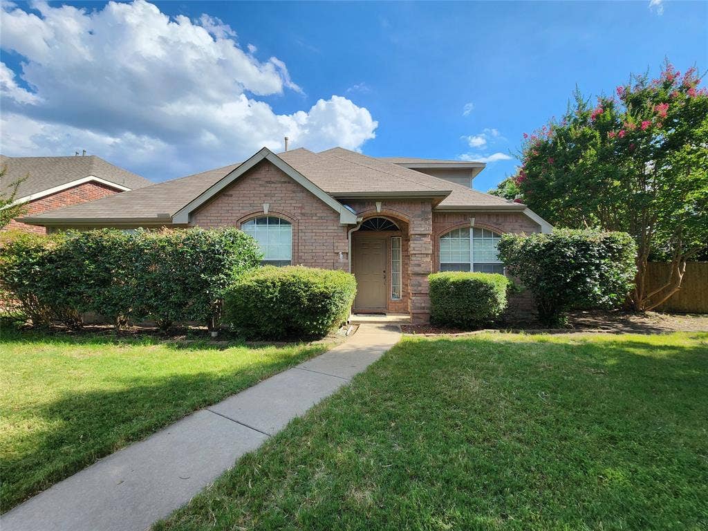 10307 Asheboro Street, Frisco, TX 75035 Brick exterior with gabled roofline, arched window, mature shrubs, and concrete walkway