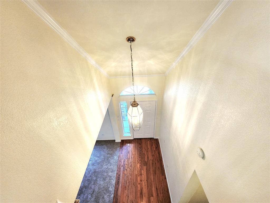 10307 Asheboro Street, Frisco, TX 75035 Two-story entry with wood-finish flooring, crown molding, and a decorative pendant light