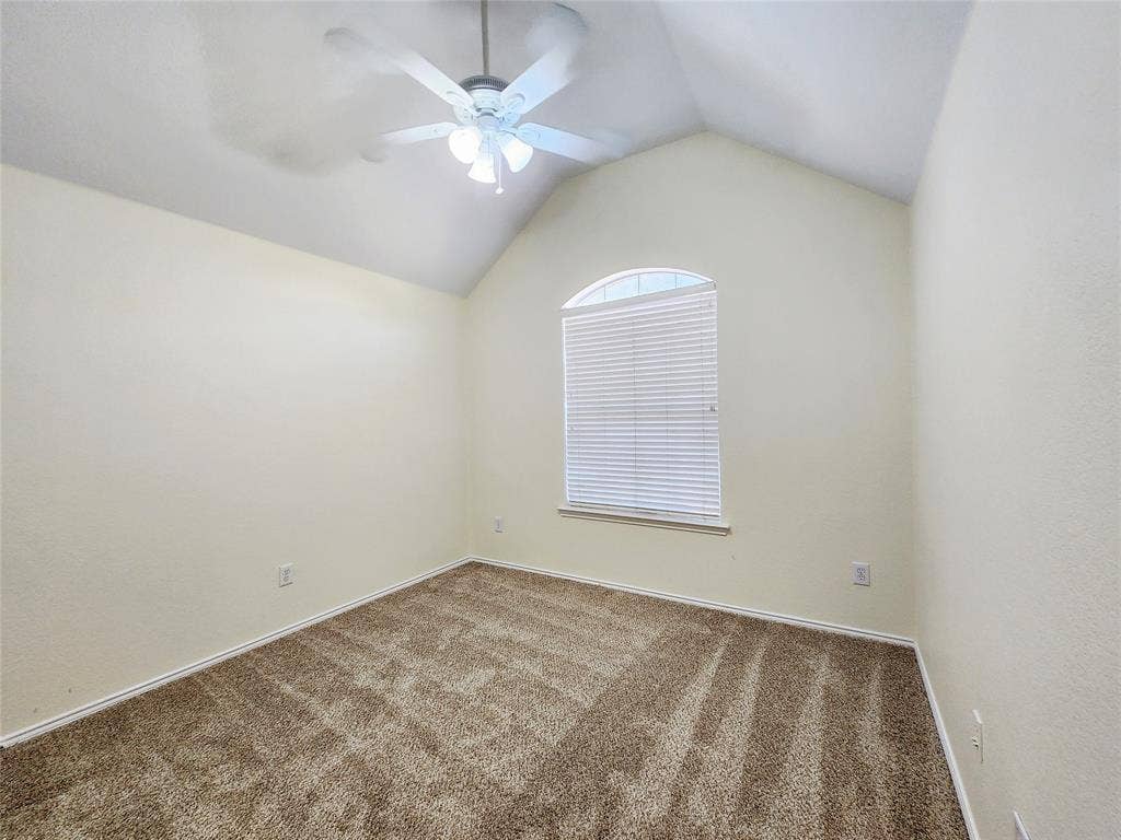 10307 Asheboro Street, Frisco, TX 75035 Arched window with blinds, vaulted ceiling, ceiling fan with integrated lighting, and neutral tone carpeting